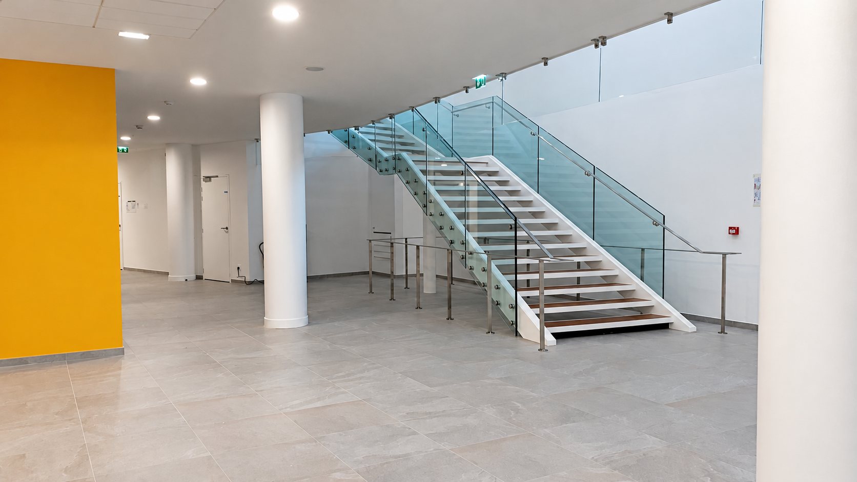 Escalier à garde-corps en verre dans un hall moderne